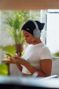 Nutzerin mit Headphones nutzt ihr Smartphone