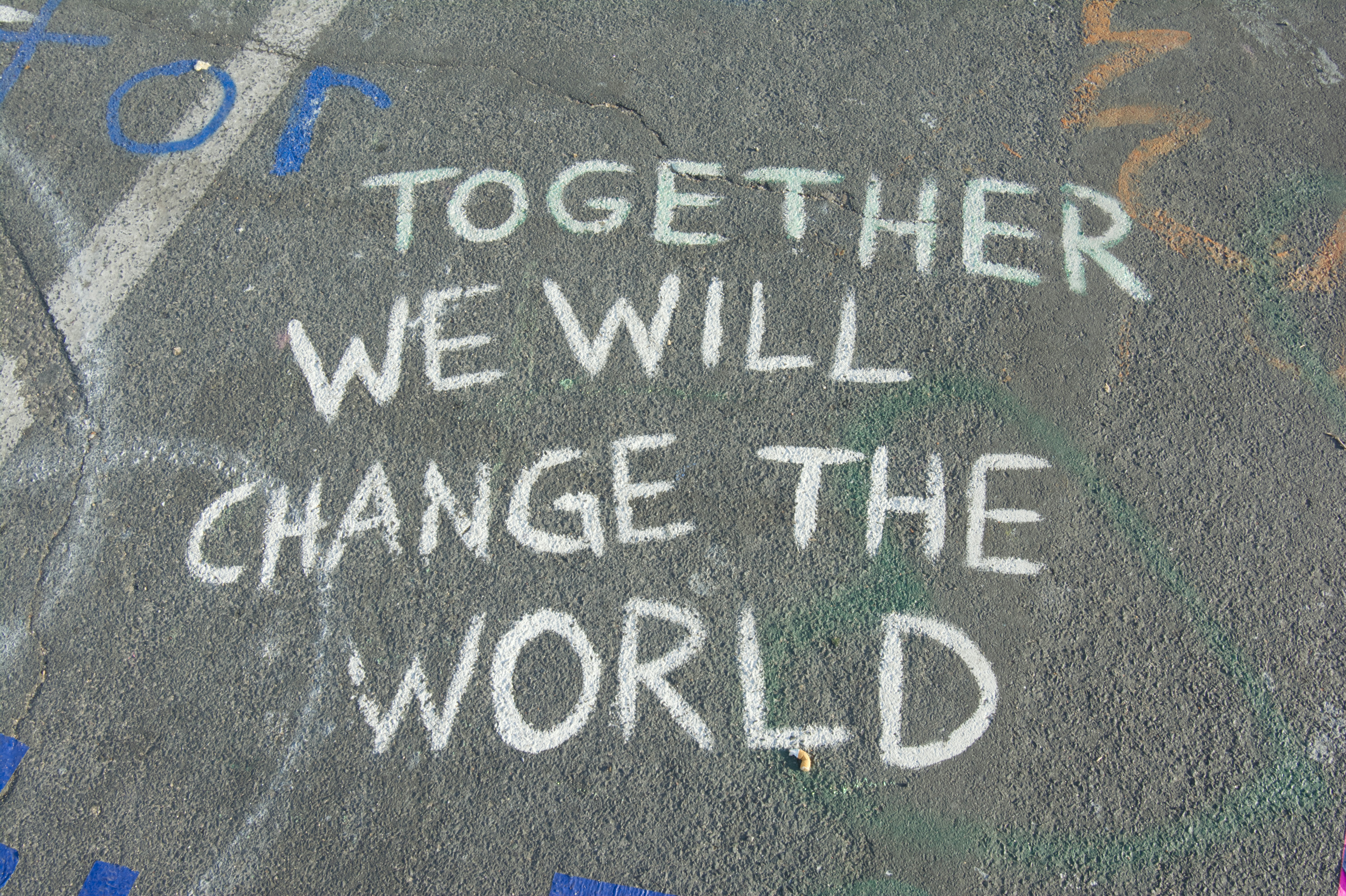 Asphalt, auf dem mit weißer Schrift "Together we will change the world" steht