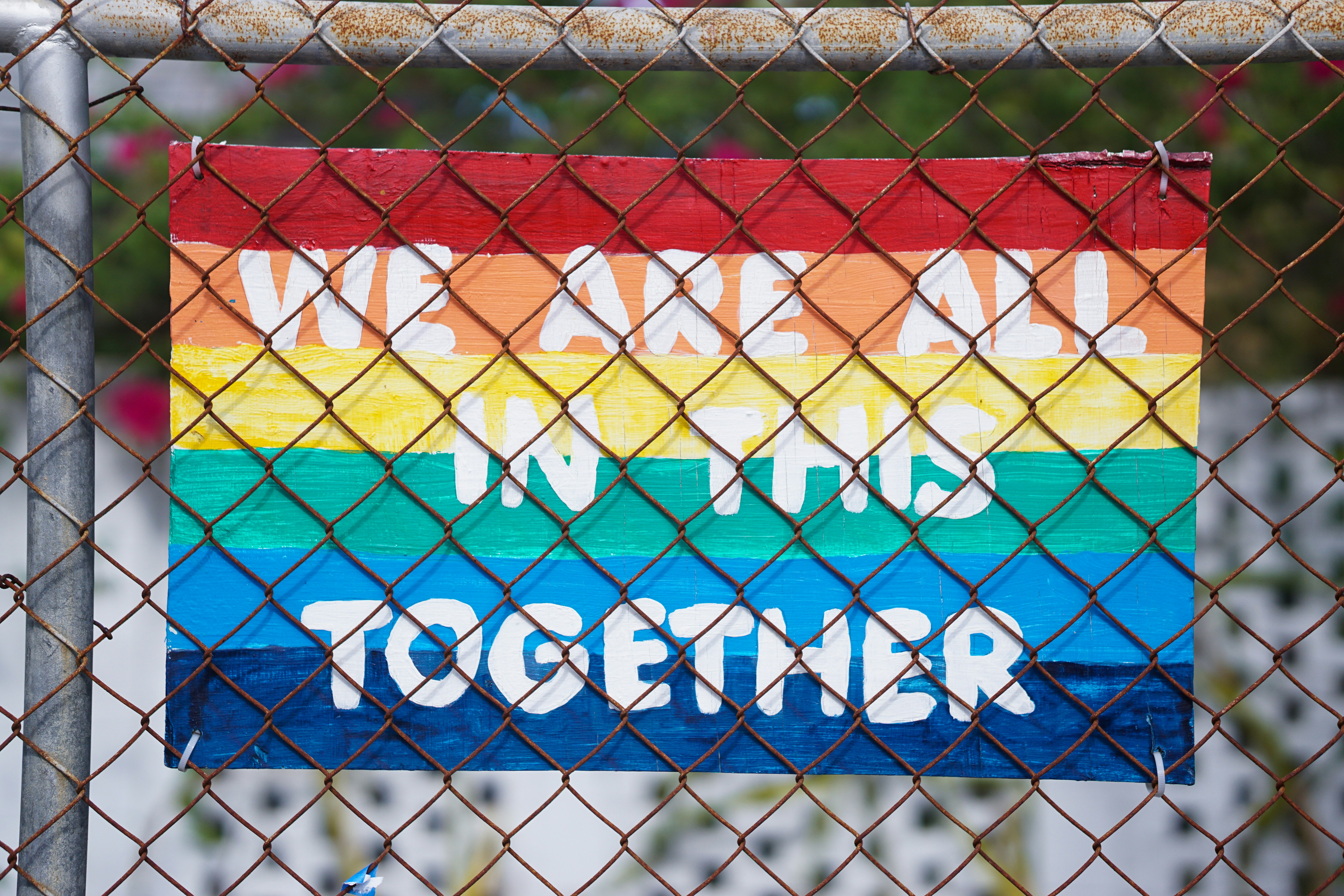 Schild in Regenbogen Farben, auf dem "We are all in this together" steht 